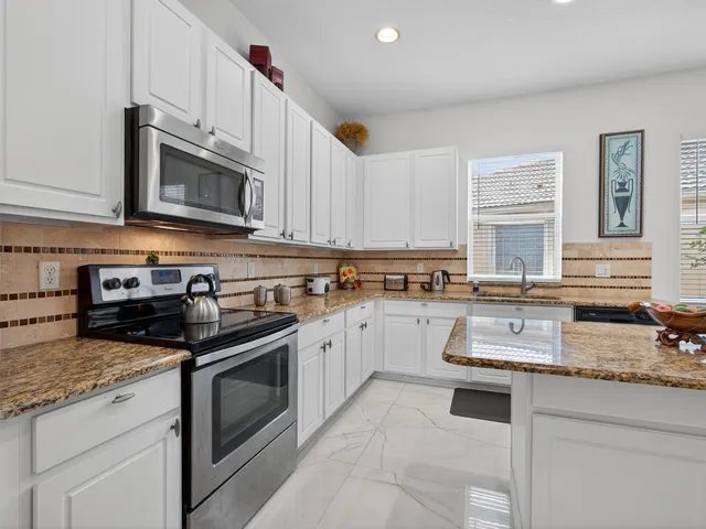 a kitchen with stainless steel appliances granite countertop a stove sink microwave and cabinets
