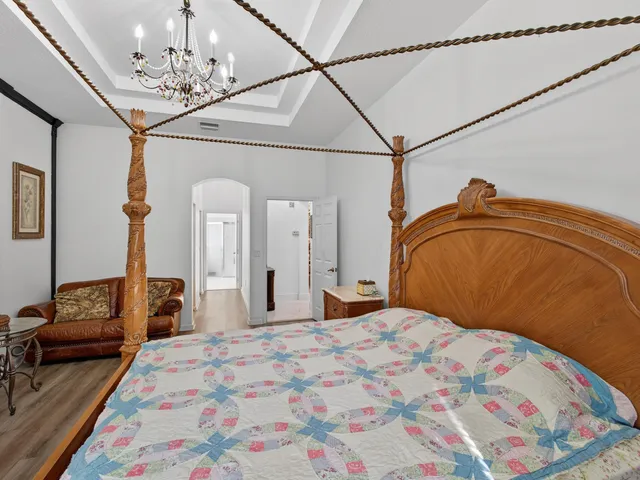 a bedroom with a bed and a chandelier