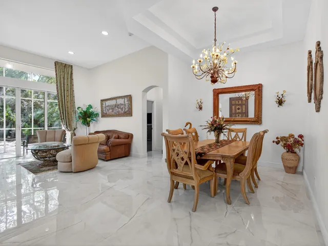 a dining room with furniture a chandelier and a rug