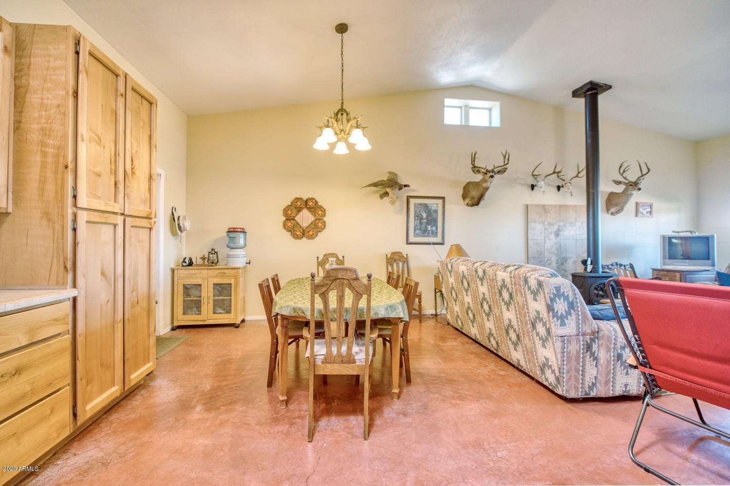 11500 South Duck Tank Road Pearce, AZ 85625 - Photo 12 of 38 a living room with furniture a chandelier and a dining table