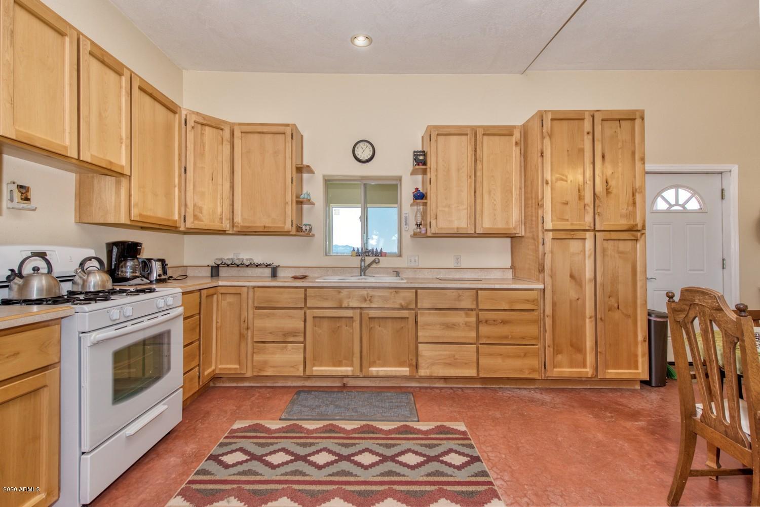 11500 South Duck Tank Road Pearce, AZ 85625 - Photo 13 of 38 a kitchen with stainless steel appliances granite countertop a stove a sink and a refrigerator