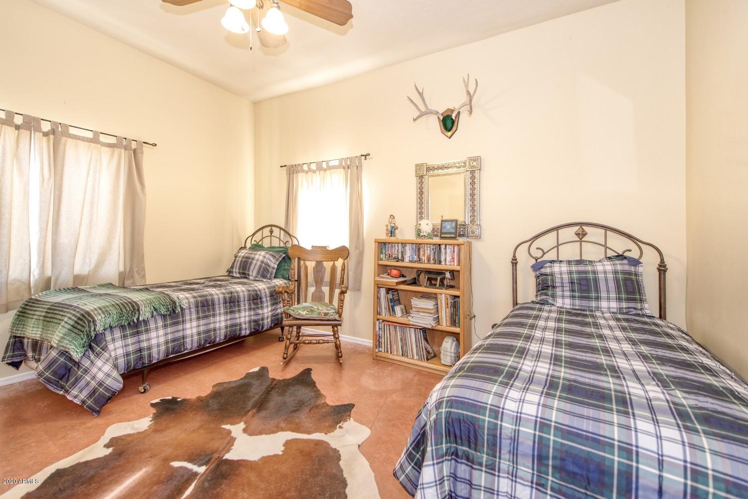 11500 South Duck Tank Road Pearce, AZ 85625 - Photo 15 of 38 a bedroom with a bed a table and painting on the wall