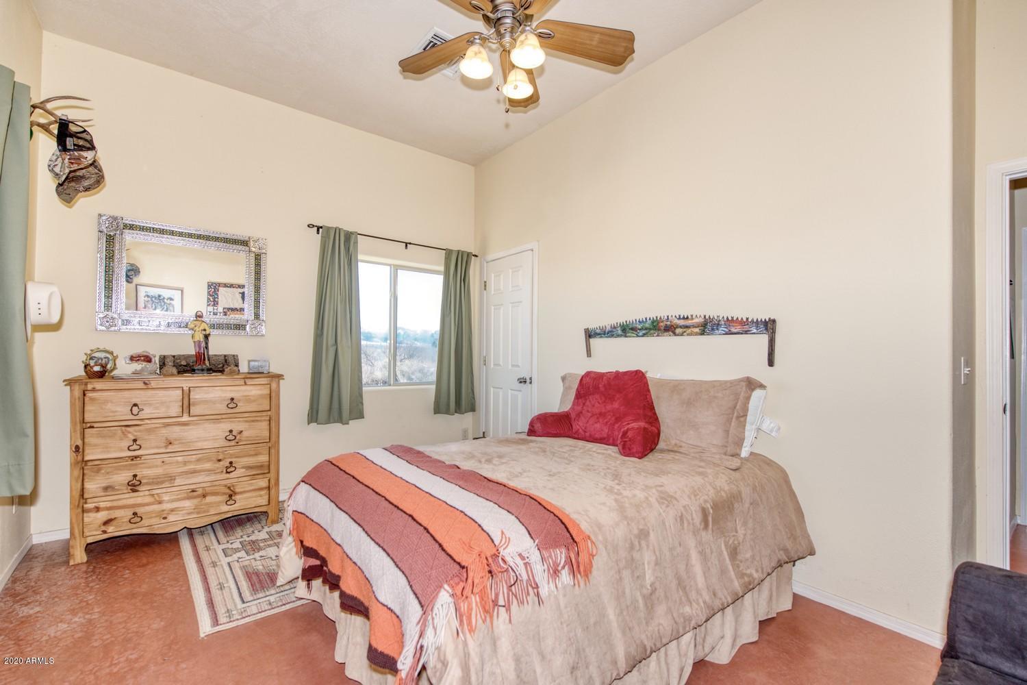 11500 South Duck Tank Road Pearce, AZ 85625 - Photo 21 of 38 a bedroom with a bed and a chandelier