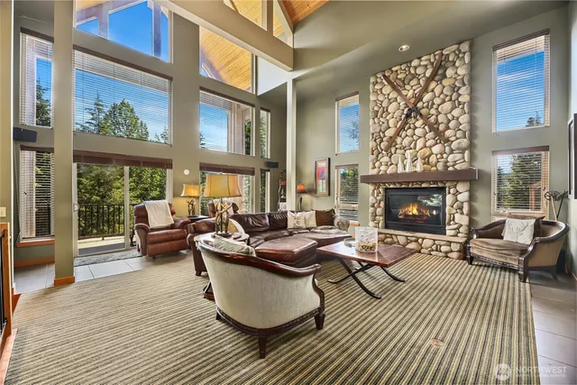 a living room with fireplace furniture and a large window