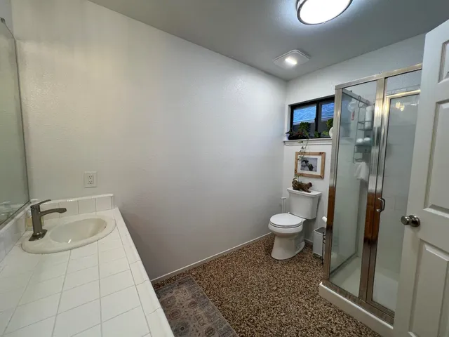 a bathroom with a toilet a sink and shower