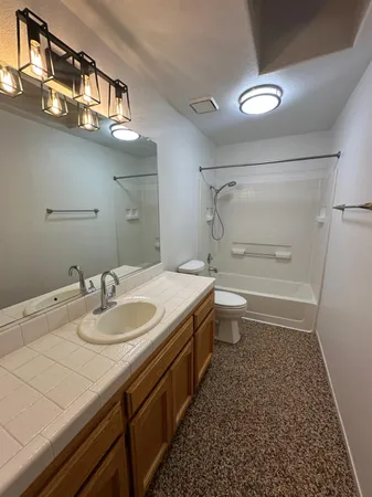 a view of an empty room with a chandelier fan