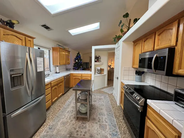 a kitchen with stainless steel appliances a refrigerator sink and microwave