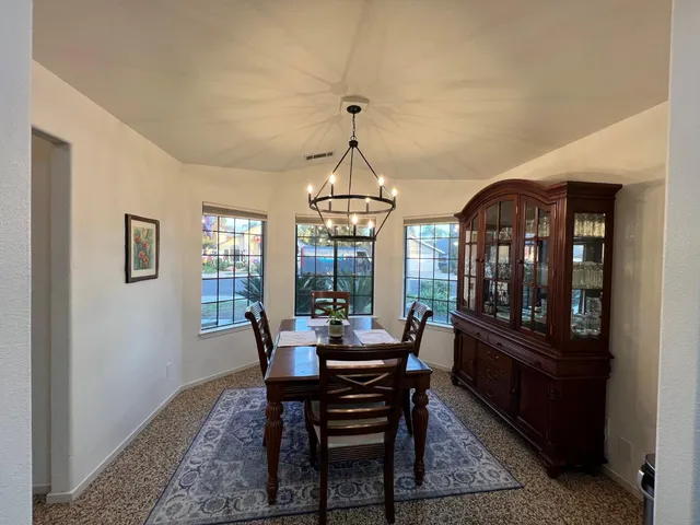 a dining room with furniture a chandelier and wooden floor