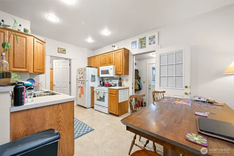 a room with a table chairs and a refrigerator
