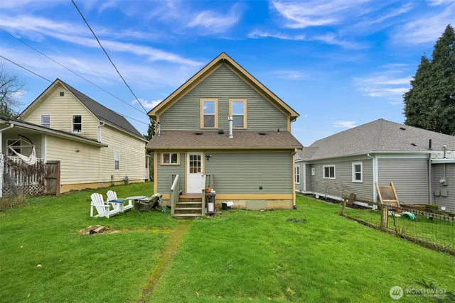 a front view of house with a garden and chairs