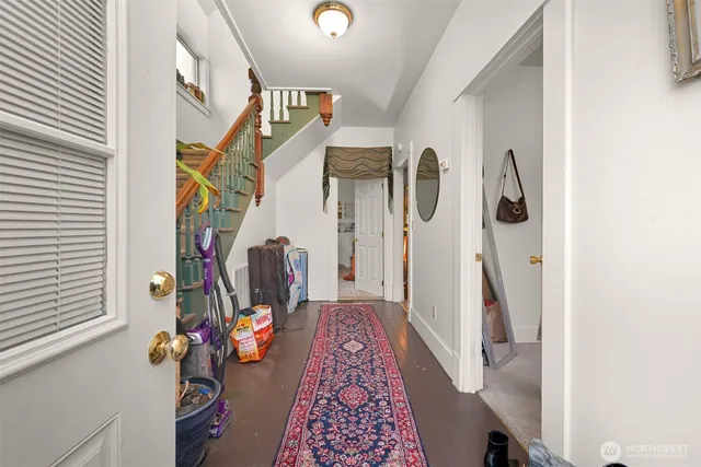 a hallway with painting on the wall and a window