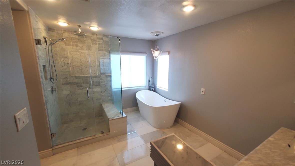 7903 Dell Ridge Avenue Las Vegas, NV 89179 - Photo 11 of 20 Luxurious bathing quarters feature a spacious walk-in shower and a free-standing soaking tub.