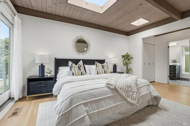 a spacious bedroom with a bed and wooden floor