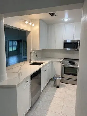 a kitchen with a sink cabinets and appliances