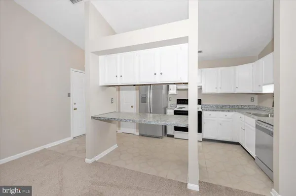 a kitchen with granite countertop a sink stainless steel appliances and cabinets