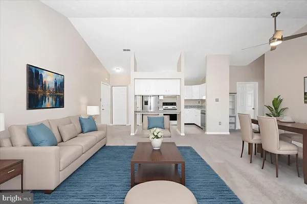 a living room with furniture kitchen view and a wooden floor