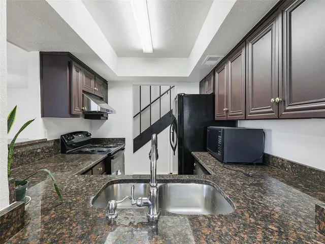 a kitchen with a sink a stove and cabinets