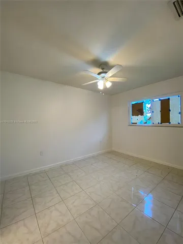an empty room with kitchen view