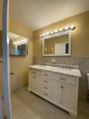 a spacious bathroom with a double vanity sink and a mirror