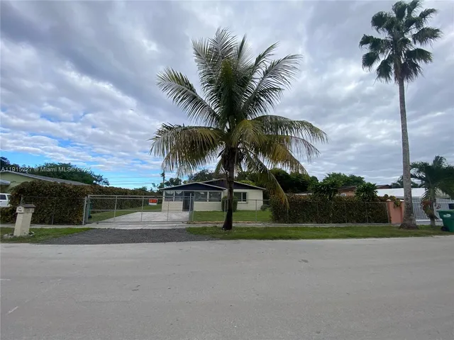 a couple of palm trees in front of house
