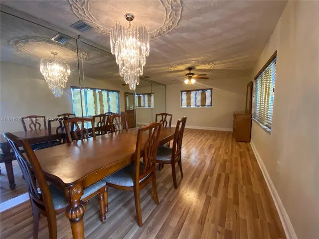 a view of a dining room with furniture a chandelier and wooden floor