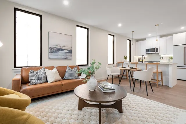 a living room with furniture kitchen and a table