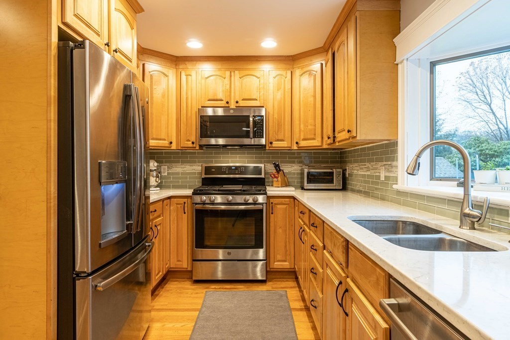 36 Sylvester Road Natick, MA 01760 - Photo 6 of 30 a kitchen with kitchen island granite countertop a sink stainless steel appliances and cabinets