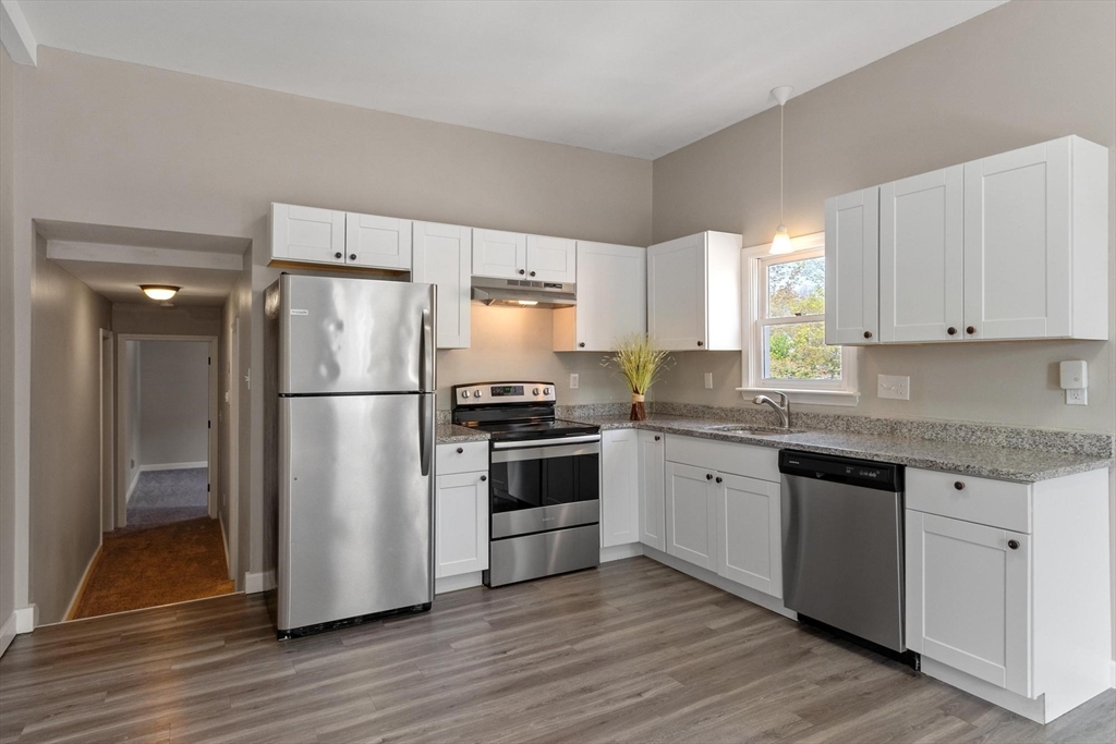 35 Cedar Street, Unit 6 Gardner, MA 01440 - Photo 6 of 33 a kitchen with a refrigerator and white cabinets