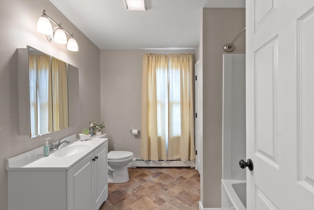 35 Cedar Street, Unit 6 Gardner, MA 01440 - Photo 9 of 33 a bathroom with a double vanity sink toilet and mirror