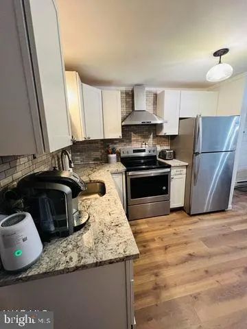a kitchen with granite countertop a sink a stove and refrigerator