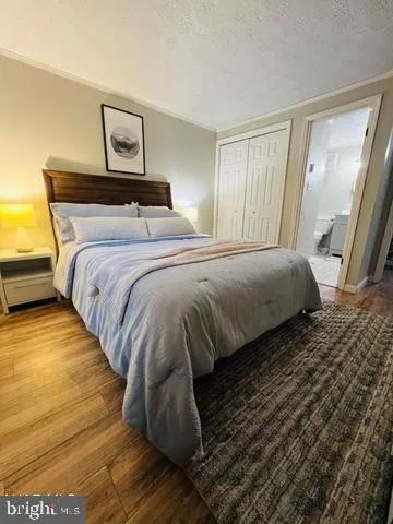 a bedroom with a bed and painting on the wall