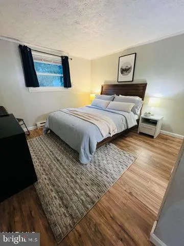 a bedroom with a bed a couch and painting on the wall