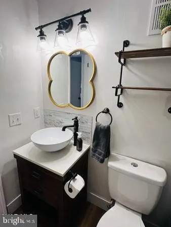 a bathroom with a toilet sink and mirror