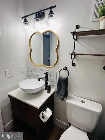 a bathroom with a toilet sink and mirror