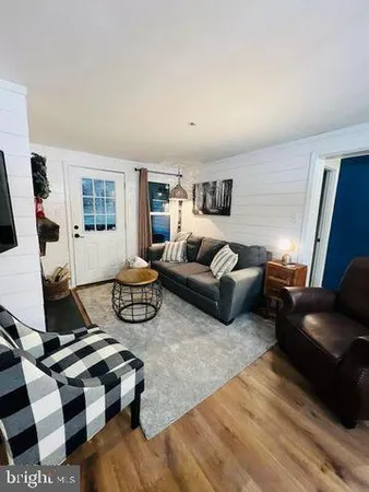 a living room with furniture a rug and a flat screen tv