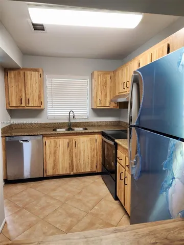 a kitchen with stainless steel appliances granite countertop a sink counter space and cabinets