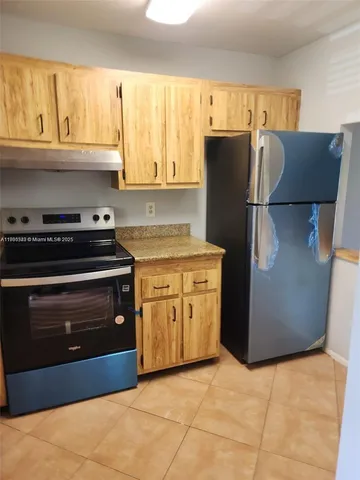a kitchen with granite countertop a refrigerator and a stove
