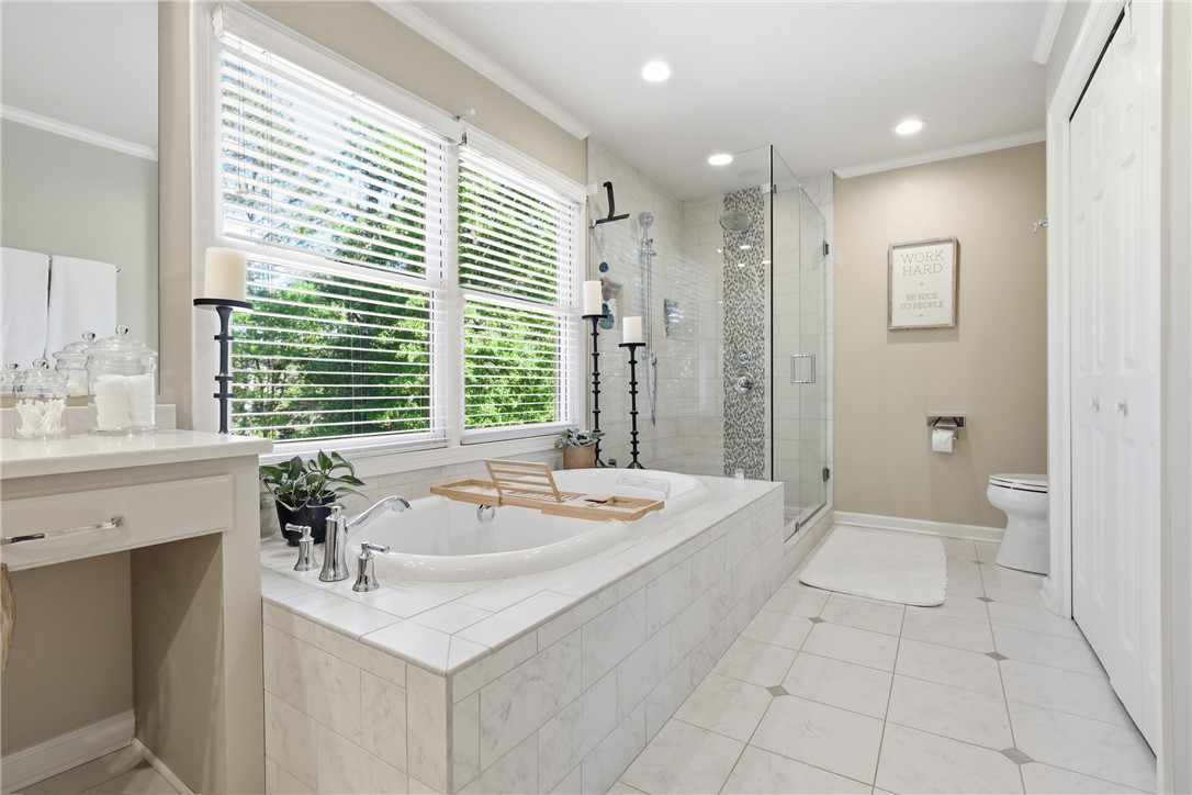 103 5 Knoll Court Anderson, SC 29621 - Photo 15 of 33 Relax in the deep soaking tub, illuminated by abundant natural light filtering through wide windows.
