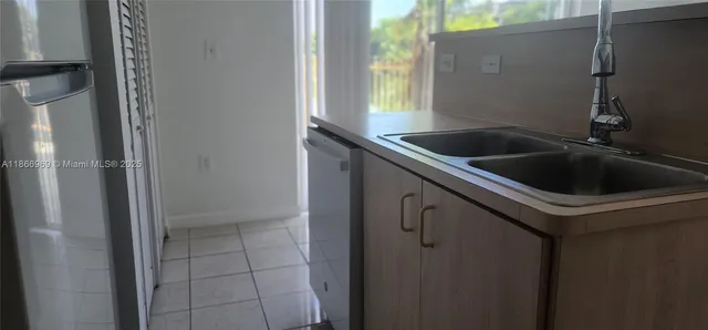 a close view of a kitchen with refrigerator and white cabinets