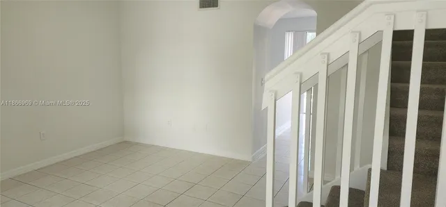 a view of staircase with railing and white walls