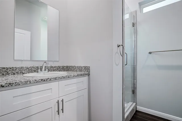 a bathroom with a granite countertop sink and a mirror