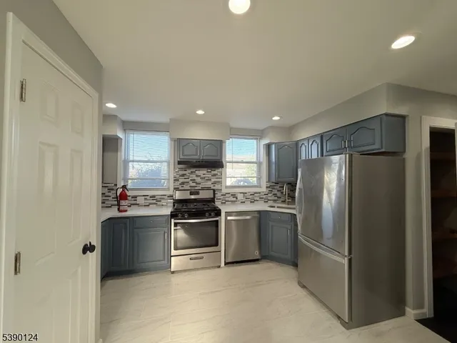 a kitchen with stainless steel appliances kitchen island granite countertop a refrigerator and a stove