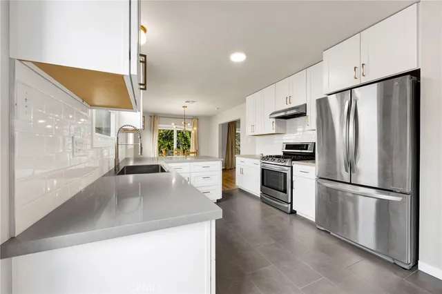 a kitchen with stainless steel appliances a refrigerator sink and stove