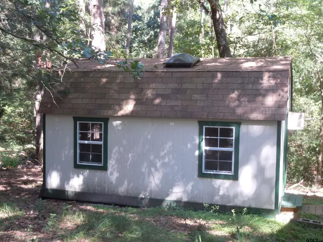 an wooden sign board with buildings in front of it