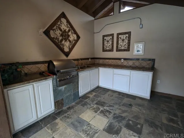 a kitchen with granite countertop a sink stove and cabinets