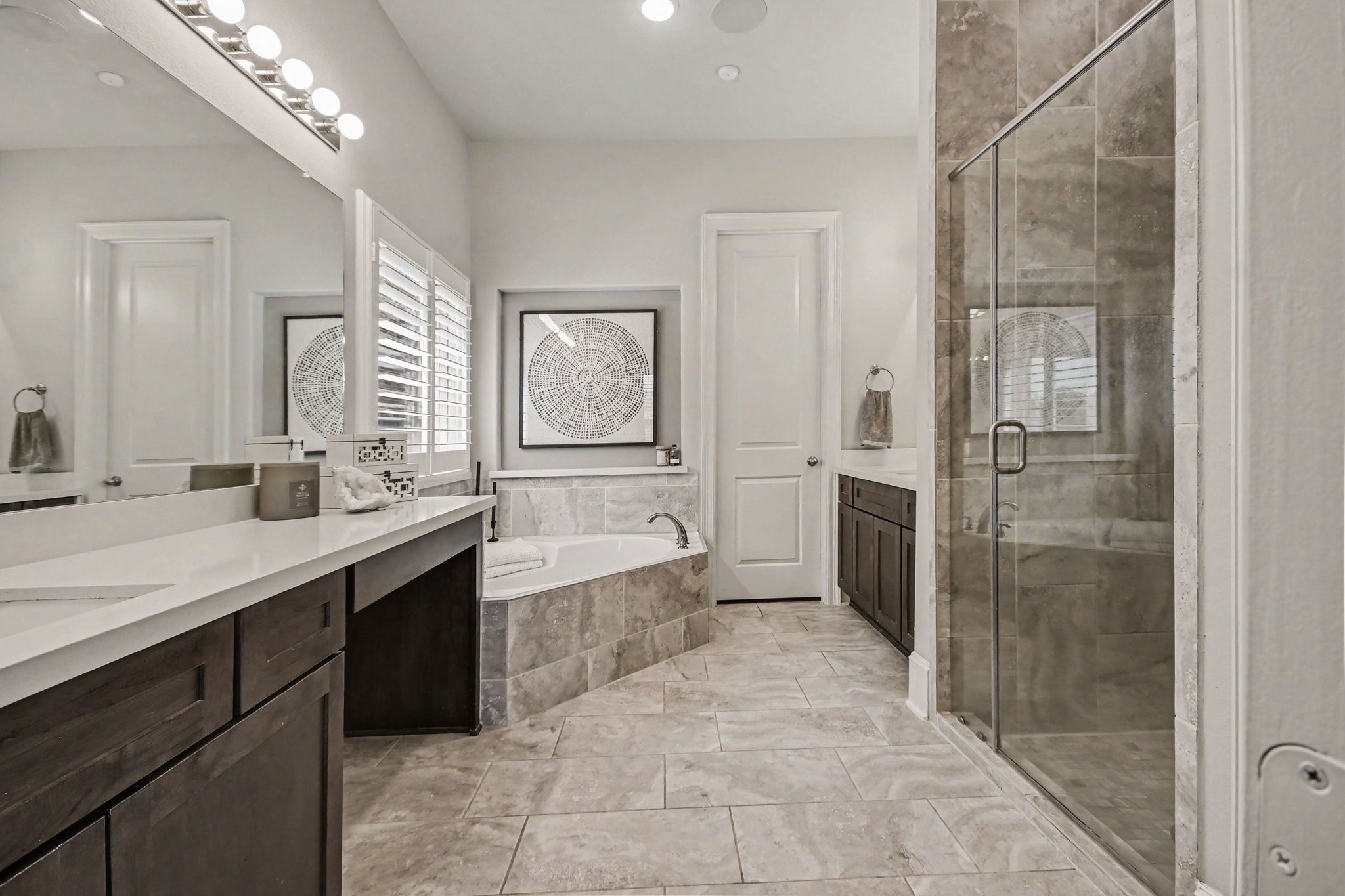 641 Kickapoo Court Webster, TX 77598 - Photo 22 of 39 This modern primary bathroom features a spacious design with a luxurious soaking tub, a large glass-enclosed shower, dual vanities with ample storage, and stylish tile flooring.