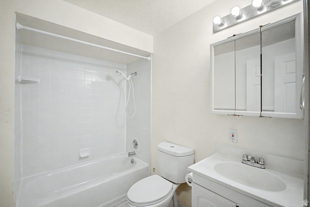 2058 California Avenue, Unit 2 Provo, UT 84606 - Photo 11 of 32 Bathroom featuring a white bathtub with subway tile surround, a white toilet, and a vanity with an integrated sink