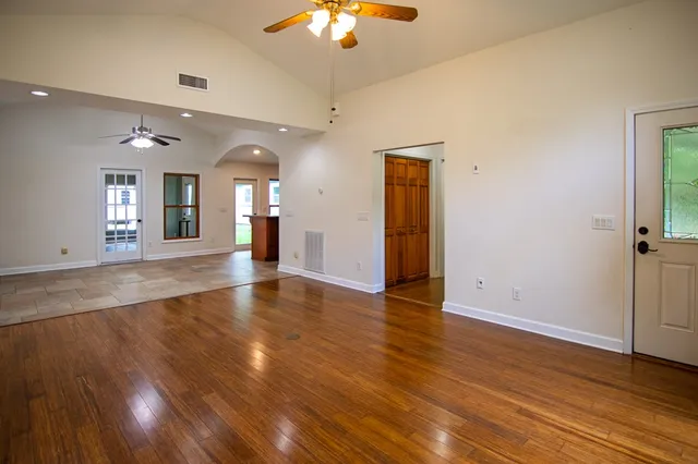 an empty room with wooden floor and chandelier