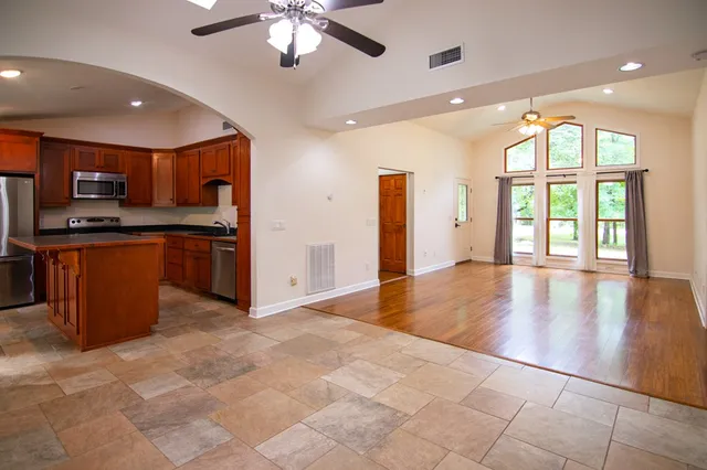 a kitchen with stainless steel appliances granite countertop a refrigerator a stove a sink and a microwave