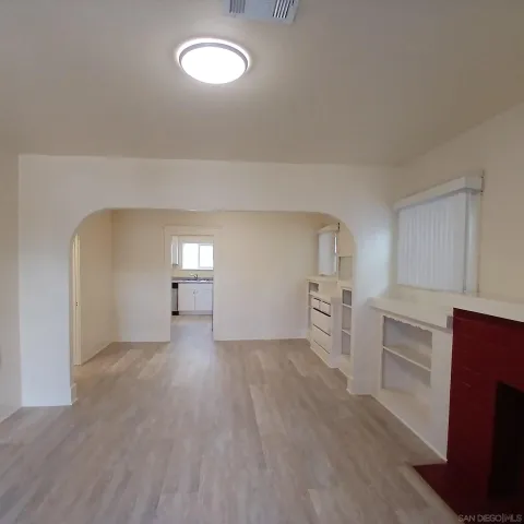 an empty room with windows and cabinet